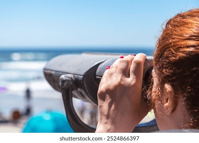 Young cute woman looking at skyline and cityscape through Coin operated binoculars or telescope. Looking through a coin operated binoculars, rear view, closeup. Coin operated in panorama observation. - Powered by Shutterstock