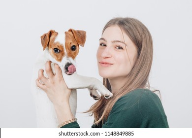 Young Cute Woman Smiles And Hugs Her Small Jack Russell Terrier Dog. Love Between Owner And Dog. Isolated On White Background. Studio Portrait.