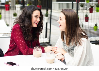 Young Cute Women Laughing While Having A Coffee Outdoors
