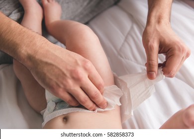 Young Dad Is Changing His Baby Diaper, Close-up