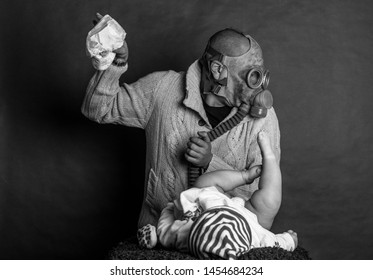 Young Dad Cleaning His Baby's Dirty Ass, Changing The Stinky Diaper In A Gas Mask, Fatherhood And Humor.
Father Changes The Baby's Diapers On A Changing Table, On A Dark, Single Track Background.