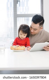 Young Dad And His Daughter Eating Pizza And Using Ipad.