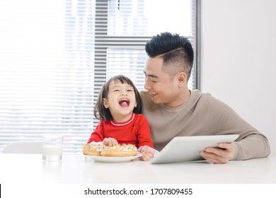 Young Dad And His Daughter Eating Pizza And Using Ipad.