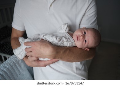 Young Dad Holding A Newborn Baby In Her Arms
