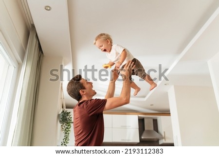 Foto Bild Junger Mann mit Kleinkind und Kindersitz verlässt eine Hütte in einer Dünenlandschaft in Dänemark