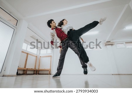 A young dance performs a dramatic partnered lift in a bright rehearsal studio. The contemporary routine captures movement, balance and trust during a casual practice session