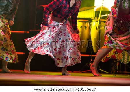 Young dancer woman barefoot in gypsy dress dancing on the stage