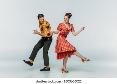 young dancers holding hands while dancing boogie-woogie on grey background - Powered by Shutterstock