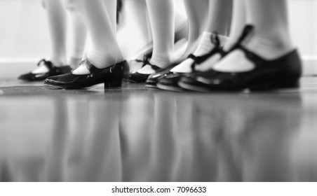 Young dancers are learning - this group is vigorously tapping with tap shoes. Lots of motion - Black and white view