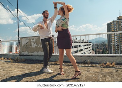 Young Dancing Couple Dance On A Rooftop Of A Building On Sunny Day