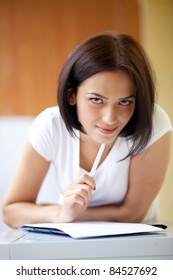 Young Dark Woman Writing On Notepad To Do List At Home