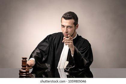 Young dashing judge in black gown making decision with no concept