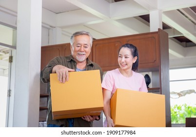 Young Daughter And Senior Father Carrying Boxes Into New Home, Happiness Family On Moving Day Concepts