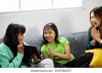 Young Daughter Showing Her Digital Drawing While Little Sister and Mother Applauding - Powered by Shutterstock