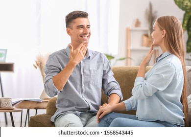 Young Deaf Mute Couple Using Sign Language At Home