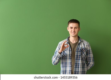 Young Deaf Mute Man Using Sign Language On Color Background