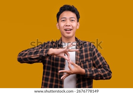 Young Deaf Mute Man Using Sign Language on Yellow Background