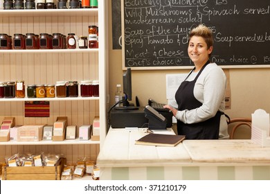 A Young Deli Worker Standing Behind The Counter