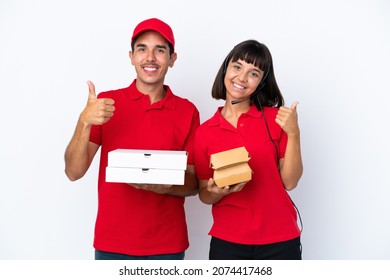 Young Delivery Couple Holding Pizzas And Burgers Isolated On White Background Giving A Thumbs Up Gesture With Both Hands And Smiling