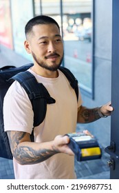 Young Delivery Guy Opening The Door And Holding Terminal