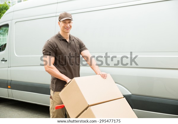 Young\
Delivery Man Holding Trolley With Cardboard\
Boxes