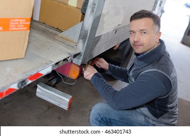 young delivery man with loading boxes in truck