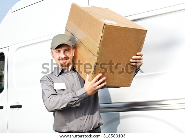 Young delivery man with parcel near cargo truck.\
Shipping service.