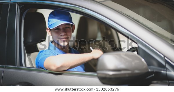 Young delivery man\
preparing the products to customer while sitting on the car, ready\
to send the products 
