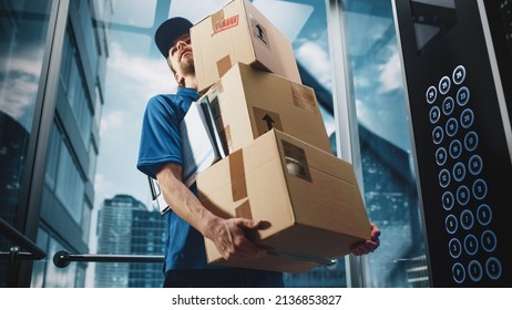 Young Delivery Person Riding Glass Elevator in Modern Office Building. Mail Courier Holding Cardboard Parcel Boxes. Handsome Mailman Delivering Fragile Packages in Business Center Lift. - Shutterstock ID 2136853827