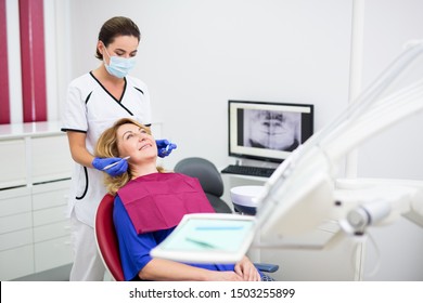 Young Dentist With Happy Mature Woman Patient At Dental Clinic