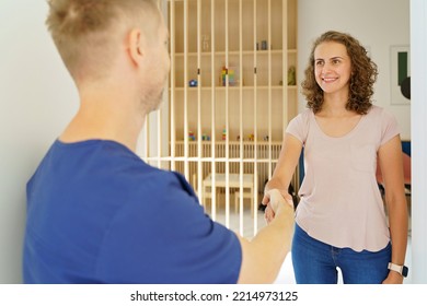 Young Dentist Shaking Hands With The Patient.