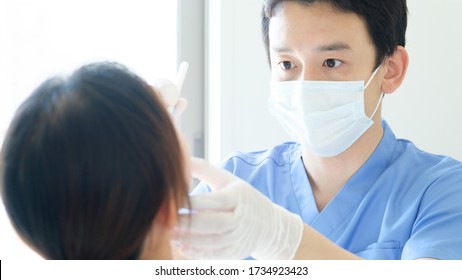 Young Dentist Treating Patient Teeth At Dental Hospital