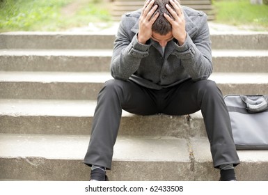 Young Depressed Businessman Sitting On The Stairs
