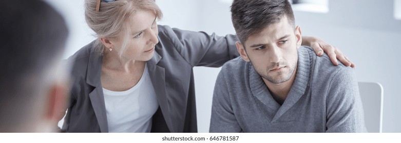 Young Depressed Young Man In Mourning Talking With Grief Counselor
