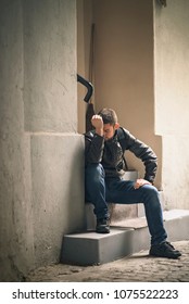 Young Depressed Man Sitting In The Dark Alleyway, Feeling Sadness And Pain