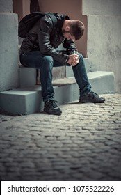 Young Depressed Man Sitting In The Dark Alleyway, Feeling Sadness And Pain