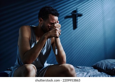 Young Depressed Man With Two Medallions On Silver Chain Crying Or Grieving About Loss Of Someone He Loved While Sitting On Bed At Night