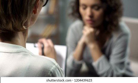Young depressed woman talking to lady psychologist during session, mental health