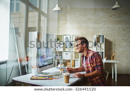 Young designer analyzing data in office