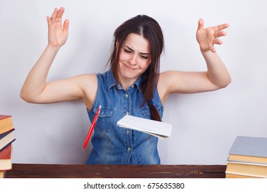 Young Desperate Angry Stressed Student Woman Sitting At The Table, Throwing A Pen And Papers. Overwork, Quit, Routine Concept