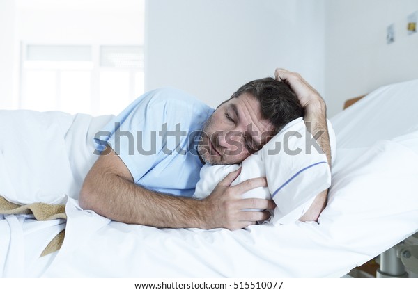 young desperate\
man lying at hospital bed alone sad and devastated suffering\
depression crying at clinic for serious disease diagnose feeling\
worried and in fear about\
health