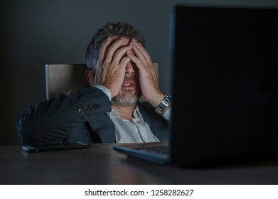 young desperate and stressed businessman working overtime at office laptop computer desk feeling anxious and overwhelmed suffering depression problem and anxiety crisis in business problem - Shutterstock ID 1258282627
