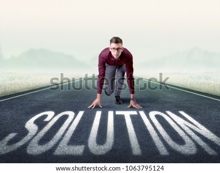 Young determined businessman kneeling before solution text