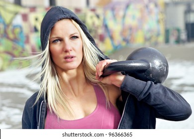 Young Determined Fitness Woman Lifting A Heavy Weight Outside In The Snow.