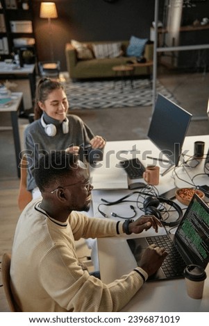 Young developers laughing and joking around when working on project in office
