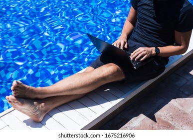 Young Digital Nomad Man Working At The Pool With A Laptop