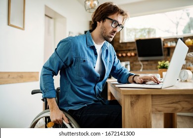 Young disabled businessman using laptop while working at home. 
