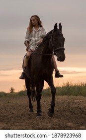 A Young Disabled Girl With A Prosthetic Leg Is Sitting On A Horse. A Person With Disabilities Leads An Active Lifestyle. Image With Selective Focus And Noise Effect And Toning.