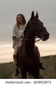 A Young Disabled Girl With A Prosthetic Leg Is Sitting On A Horse. A Person With Disabilities Leads An Active Lifestyle. Image With Selective Focus And Noise Effect And Toning.