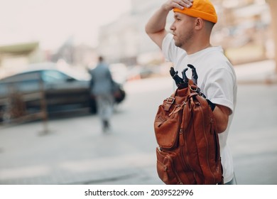 Young disabled man hold backback leather bag with artificial prosthetic hand in casual clothes